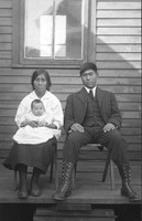 Couple with baby in front of home